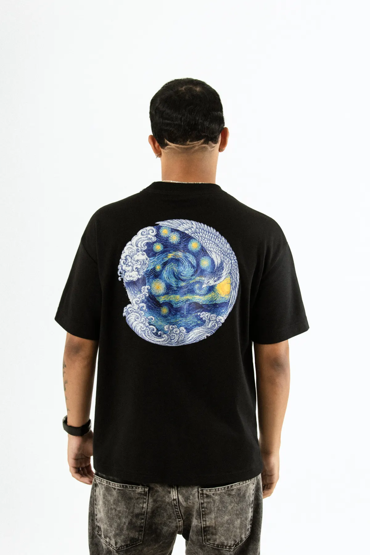 Modelo de costas, com a camiseta preta e a estampa circular de Noite Estrelada.